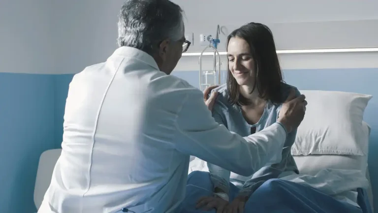 Cuidado humanizado está sendo mostrado na imagem com médico pondo as mãos no ombro de uma paciente mulher